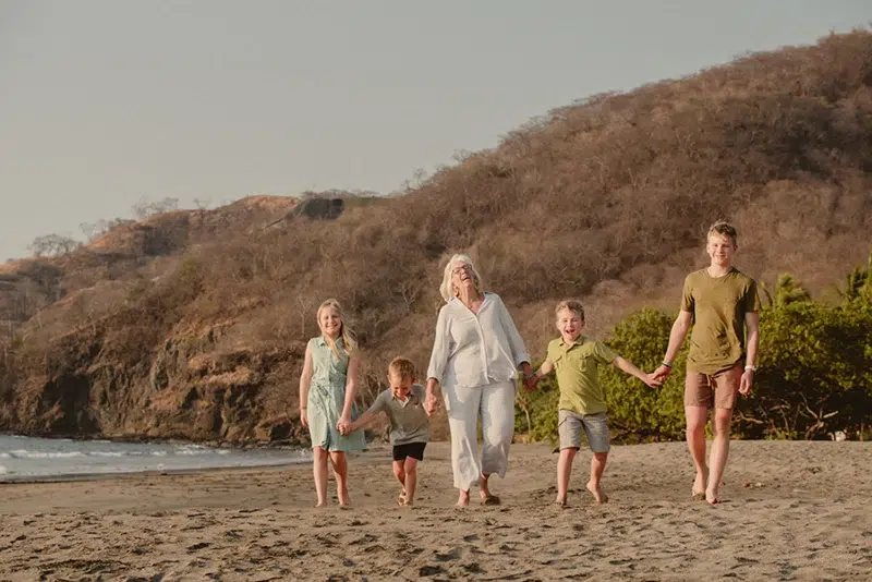 Walking Together: A Grandmother’s Love A grandmother walking along the shore, holding hands with her four grandchildren. Costa Rica Wedding Photographer. Monteverde, La Fortuna, Manuel Antonio, Tamarindo, Puerto Viejo, Uvita
