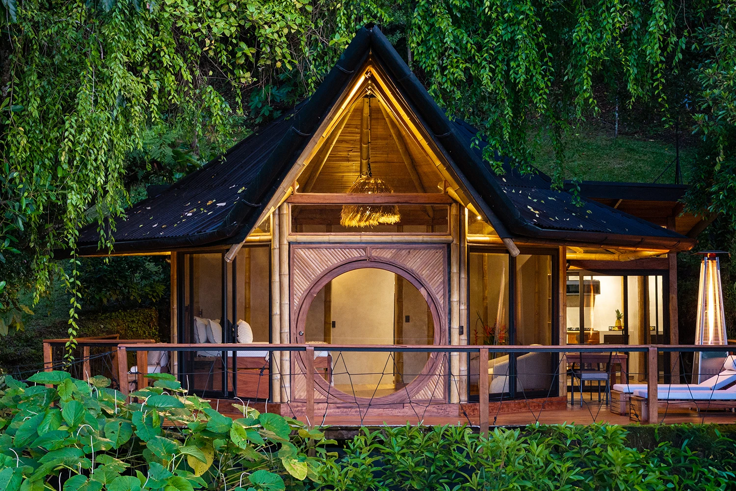 Forest Cabin at El Tigre Waterfall. Deep Forest Studio Wooden cabin façade surrounded by lush forest at El Tigre Waterfall.