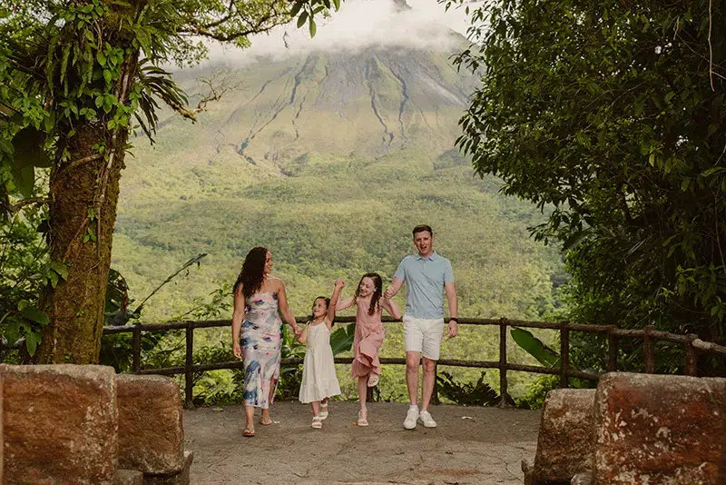 Family Adventure at Arenal Volcano Family walking together with the Arenal Volcano in the background in La Fortuna