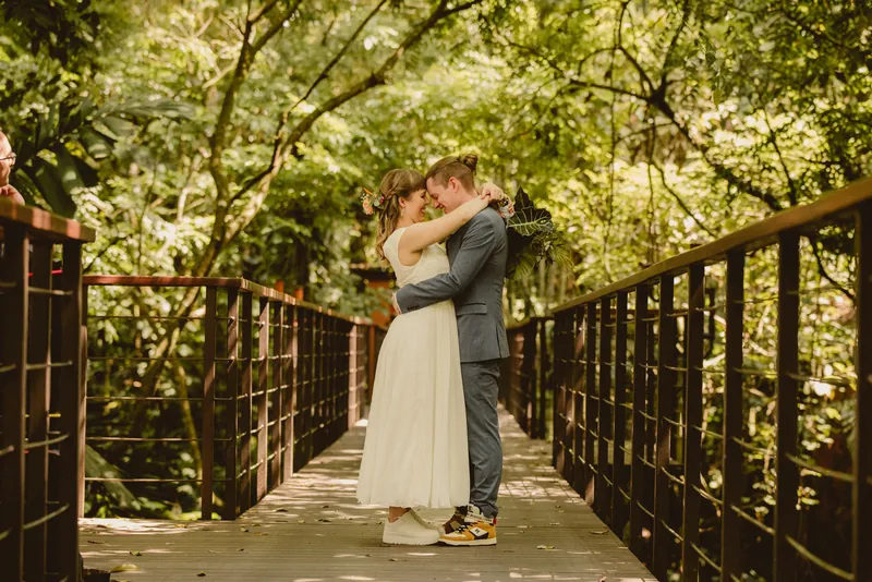 La Fortuna wedding photographer capturing the couple's first look on a forest bridge surrounded by lush greenery, Costa Rica