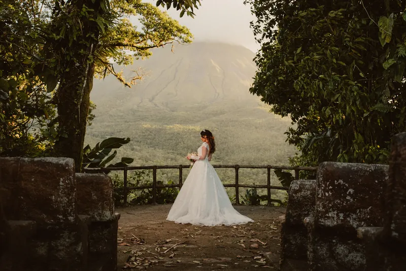 La Fortuna wedding photographer portrait of bride Yarit standing at a misty mountain viewpoint, Arenal Volcano area, Costa Rica