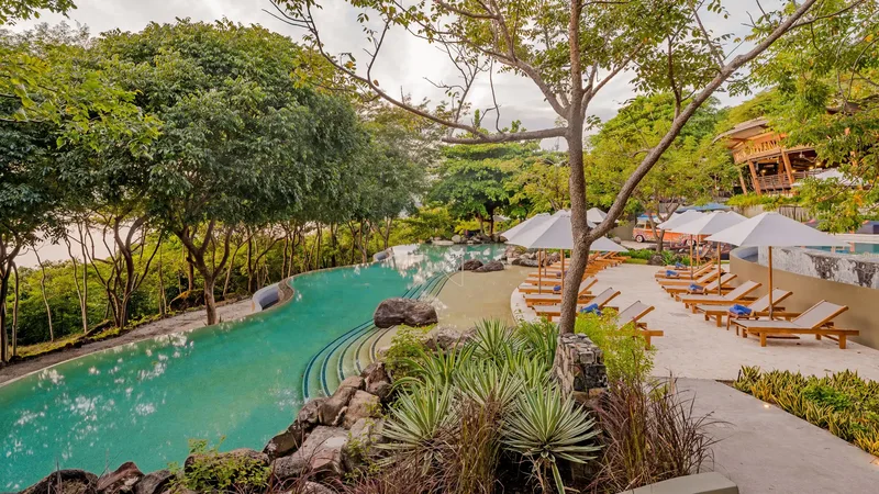 Infinity pool and sun terraces surrounded by tropical forest at Andaz Costa Rica Resort in Guanacaste