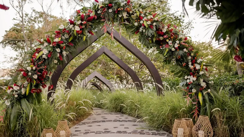 Red and white floral wedding arch at the whale-shaped sculpture entrance of Andaz Costa Rica Resort
