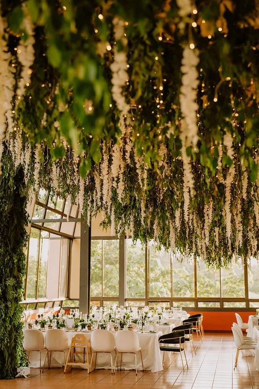 Cascading white and green floral ceiling installation over a wedding reception at Arenal Kioro, La Fortuna, Costa Rica