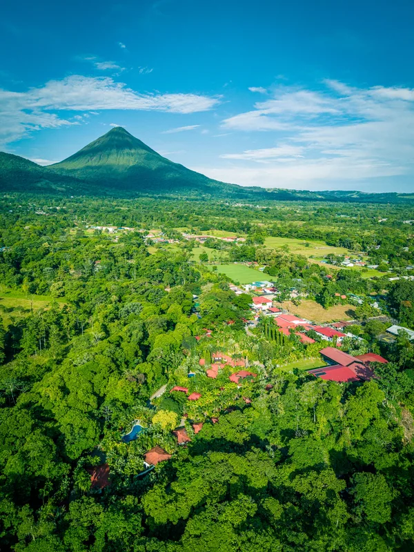 Aerial view of Arenal Volcano rising above the rainforest and Casa del Río grounds in La Fortuna, Costa Rica