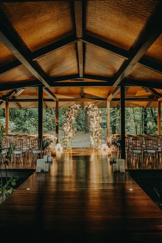 Covered wooden ceremony pavilion with a white floral arch and aisle at El Silencio Lodge & Spa in Bajos del Toro, Costa Rica