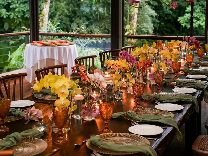 Wedding reception table with yellow orchids, amber glassware and green napkins at El Silencio Lodge & Spa, Bajos del Toro, Costa Rica