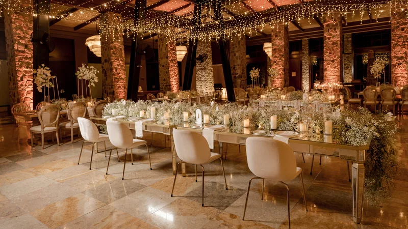 Luxury wedding reception with long candlelit tables and stone columns at Four Seasons Resort Costa Rica, Peninsula Papagayo