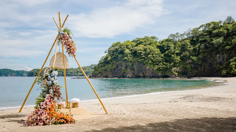 Bohemian tipi-style floral ceremony arch on the beach at Four Seasons Resort Costa Rica, Peninsula Papagayo, Guanacaste