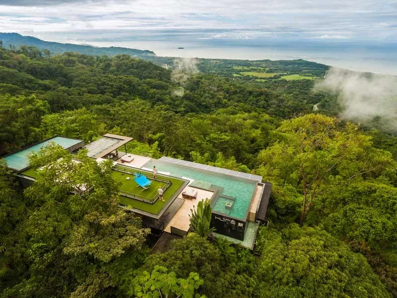 Aerial view of Kura Boutique Hotel surrounded by rainforest and mist above the Uvita coastline, Costa Rica