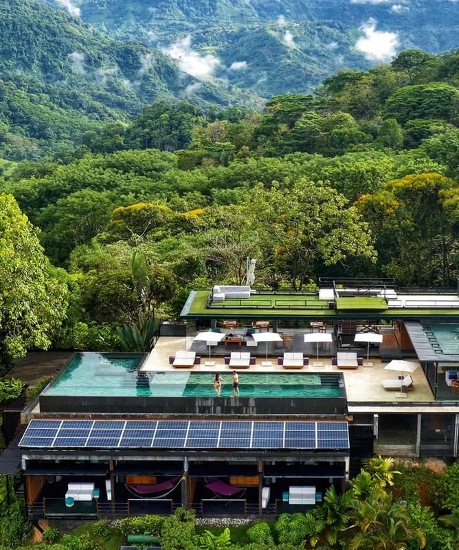 Aerial view of Kura Boutique Hotel with green roofs and infinity pool in the rainforest mountains of Uvita, Costa Rica