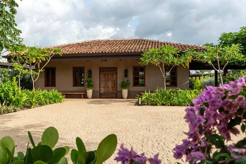 Gran Casona hacienda building with a courtyard of trees and hanging lanterns at Nekajui Ritz-Carlton Reserve, Costa Rica