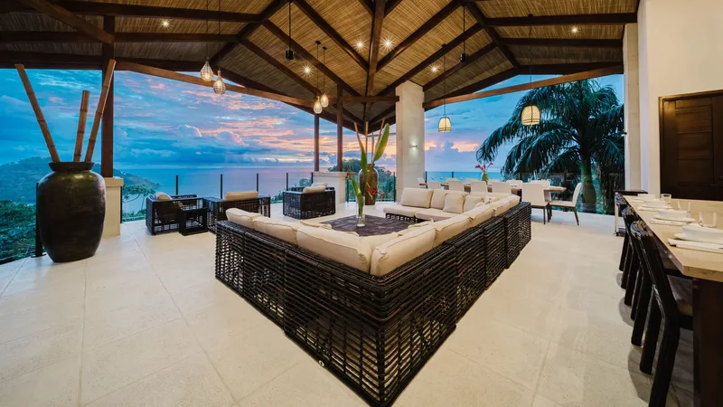 Open-air villa terrace with lounge seating and ocean view at dusk at Tulemar Resort, Manuel Antonio, Costa Rica