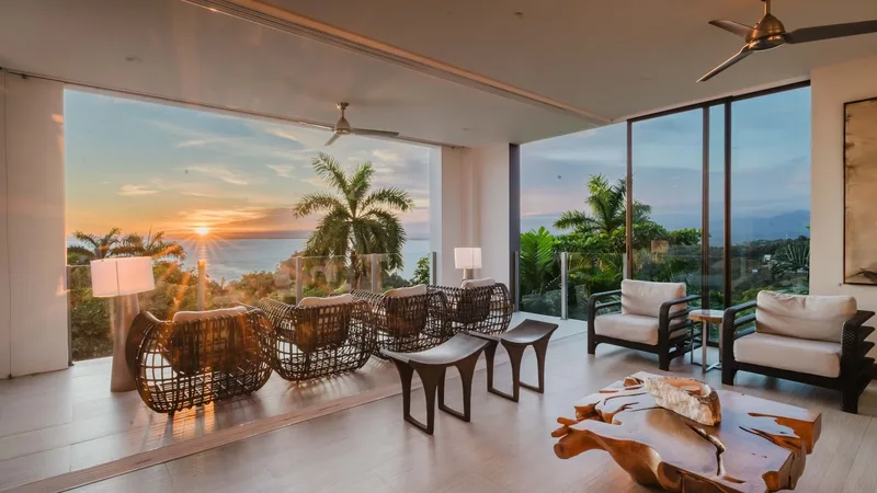 Luxury villa living room with floor-to-ceiling windows and a sunset ocean view at Tulemar Resort, Manuel Antonio, Costa Rica