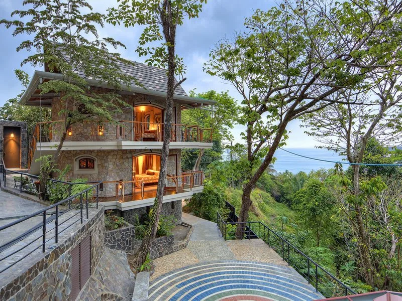 Stone villa with balconies and a winding staircase in the rainforest at Villa Punto de Vista, Manuel Antonio, Costa Rica
