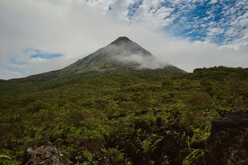 Arenal Volcano view from Reserva El Silencio, La Fortuna Arenal Volcano rising above green rainforest under a partly cloudy sky, seen from Reserva El Silencio in La Fortuna, Costa Rica